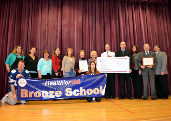 Photo of state, county and school officials displaying the Healthier US School Challenge Awards