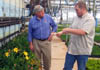 Photo of Secretary Kuperus and Bob Blew looking at Day lilies