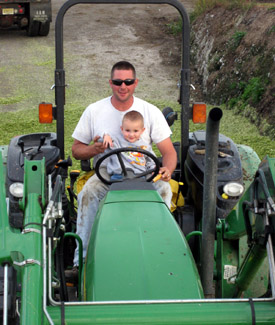 Photo of Henry Byma on a tractor with his son.