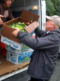 Photo of Secretary Kuperus loading donated produce onto a food pantry truck