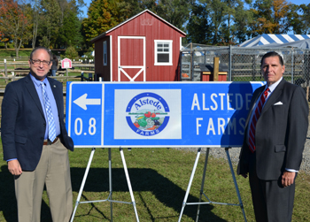 Photo of Secretary Fisher and Deputy DOT Commissioner Mrozek with an example of a TODS sign