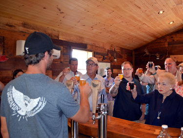 Photo of Secretary Fisher offering a toast to the new brewery