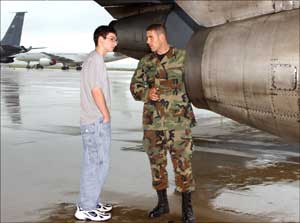 Senior Airman Dominick Rodriguez (right) explains to a friend how the engine on a KC-135E Stratotanker works