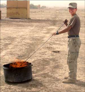 Pfc. Katie Meisenbacher buring waste. Photoby Sgt. 1st Class Kevin E. Lewis, 253rd Transportation Company