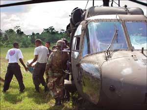 Aid workers and Guardsmen unload emergency relief supplies from a 150th GSAB Blackhawk at Boco de Cupe.