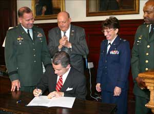 Governor James E. McGreevey signs the National  Guard Week Proclaimation while Brig. Gen. Glenn K. Rieth, Assemblyman Joseph Azzolina, Col. Maria Morgan and State Command Sgt. Maj. Richard S. Atkins watch.