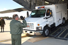 A member of the Mississippi Air National Guard guides a member of the CST during the loading of the C-17.  Click to enlarge