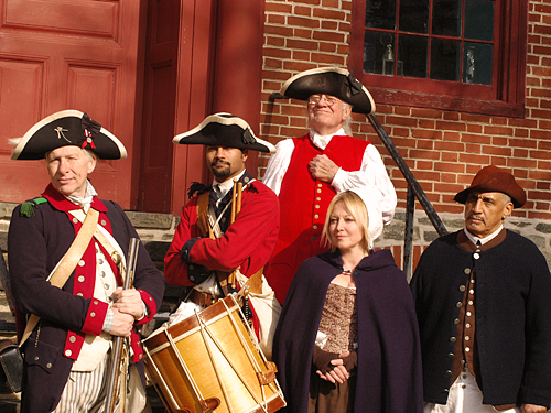 Some of the historical interpreters of the Old Barracks on the steps of the officers' quarters