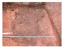 Opening view of buried historic privy. Note later drainpipe leading into earlier feature indicated by dark stain on surface
