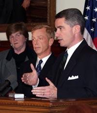 Governor McGreevey (right) presents 'Fix DMV' report at a November 7 news event. With him are DMV Director Diane Legreide and Transportation Commissioner Jamie Fox.