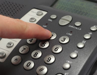 Photo of Person Dialing a Telephone