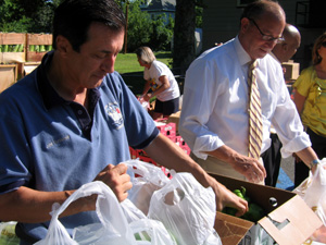 Photo of Assemblyman Burzichelli and Secretary Fisher bagging Jersey produce