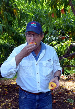 Photo of Secretary Fisher enjoying a Jersey peach