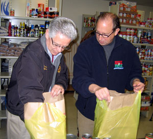 Photo of Assemblyman Jack Conners and Secretary Fisher packing groceries