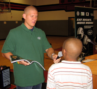 Photo of Jets Kicker Nick Folk handing out a prize during the program