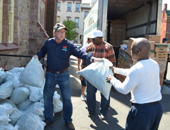 Photo of Secretary Fisher distributing fresh produce at Holy Cross Church