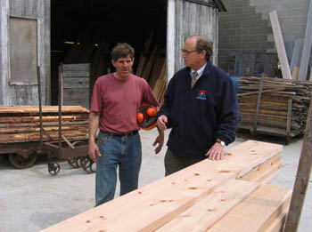 Paul Schairer and Secretary Fisher look at wood milled from NJ trees