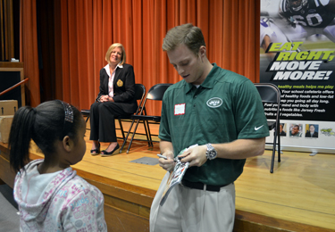 Photo of Greg McElroy awarding a prize at Hess School