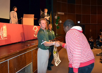 Photo of Greg McElroy and Julian Posey awarding a prize to a student during the Eat Right, Move More Program