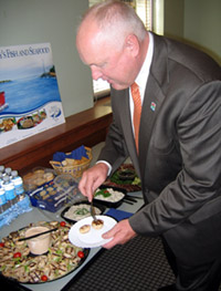 Photo of Secretary Kuperus inspecting Jersey Seafood dishes at Seafood Challenge Kickoff