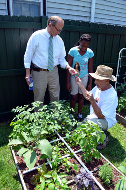 Photo of Secretary Fisher, Capri Christmas and Bob Markey at the square foot garden