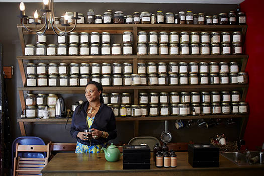 Woman of color salesperson in shop with products: Photo