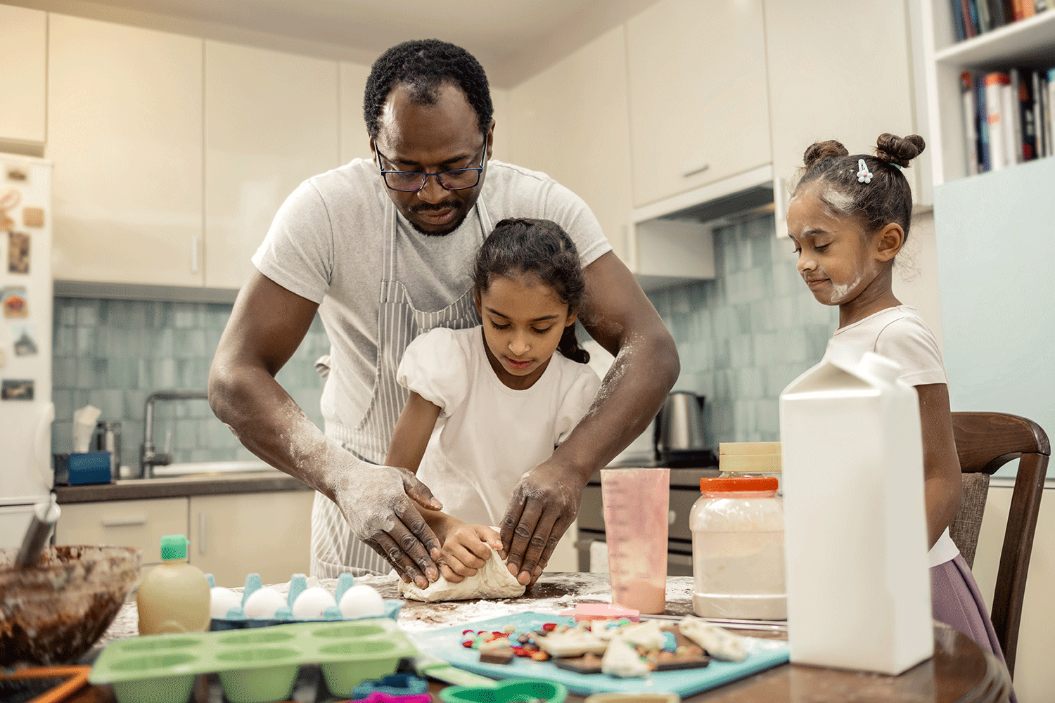 father and two daughters baking