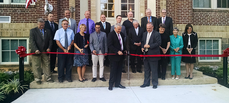 People cutting the ribbon to celebrate the opening of 53 Units of Affordable Rental Housing for Senior Citizens.