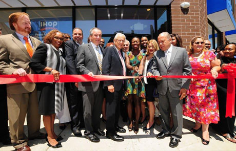 People cutting the ribbon to celebrate the opening of IHOP restaurant.