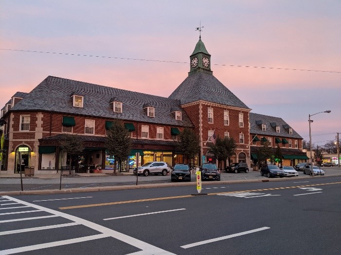 A big building with a road and cars parked on the sides