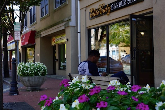 A man sitting on bench and lookind at his cell phone