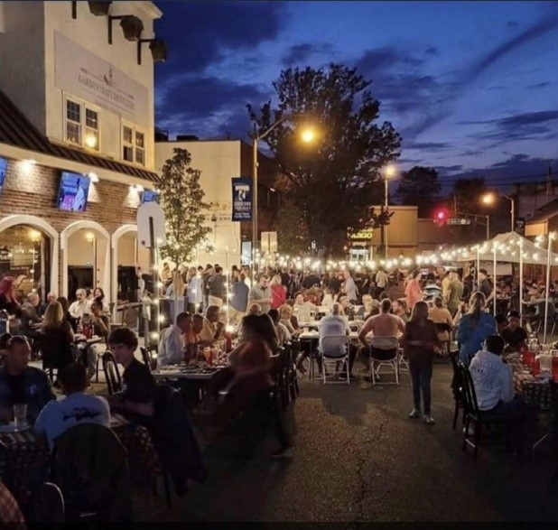 An outside restaurant with big amount of people and lights