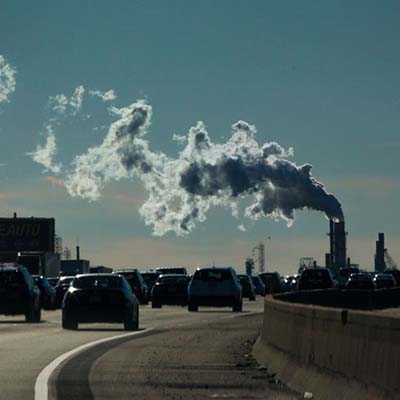 Industrial smoke is emitted into the sky over vehicles moving along the New Jersey Turnpike in Carteret.