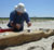 Australian shorebird researcher Clive Minton sorts shorebirds into burlap-covered cages.