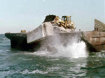 Concrete bulldozed off barge