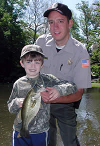 Young angler with bass and officer