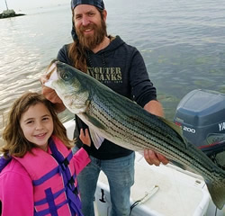 Father and daughter with striped bass