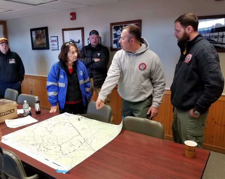 DEP Commissioner Catherine R. McCabe is briefed on the fires status by Forest Fire Service personnel