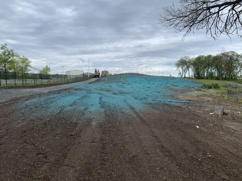 Hydroseed being broadcasted behind the Kroc Center above the Northern Tidal Wetland area