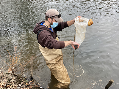 DRBC staff collect a water sample from the Assunpink Creek to monitor for microplastics. Photo by DRBC.