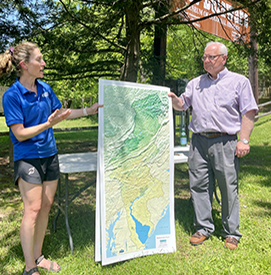 DRBC Director of External Affairs & Communications Elizabeth Brown poses with Delaware Company President John Conway and a large 3D map of the DRB. These maps were produced as part of DRBC's Our Shared Waters program. Photo by the DRBC.