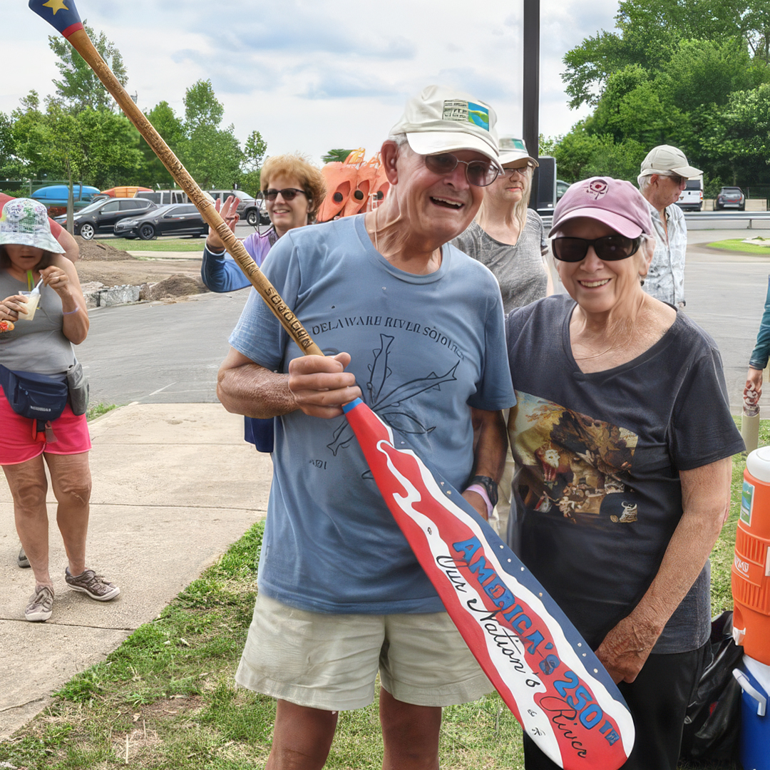 Sojourner John Powers (L) won the 2026 Sojourn paddle in the raffle. Paddle designer Sandy Schultz is pictured with him (R). Photo courtesy of Rachel Burmeister.