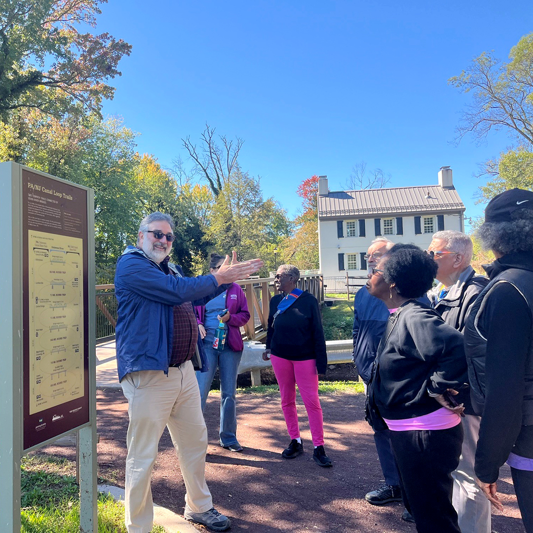 Trenton Walks! Leader Tim Brill uses the trail map to orient folks to the canal loop trails connecting PA & NJ. Photo by the DRBC.