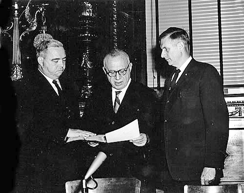 At its March 28, 1962 meeting, the DRBC commissioners unanimously approved the 20-point First Phase Comprehensive Plan and appointed James F. Wright as the DRBC's first executive director. John P. Robin, who was instrumental in the Compact negotiations, had served as acting executive director prior to Wright's appointment. Mr. Wright, who previously held the position of chief deputy director of the California Water Resources Department, is shown above (on the left) being sworn in by Judge Joseph Sloan at Philadelphia City Hall on May 23, 1962. Observing the ceremonies (right) is Pennsylvania Secretary of Forests and Waters Maurice Goddard.