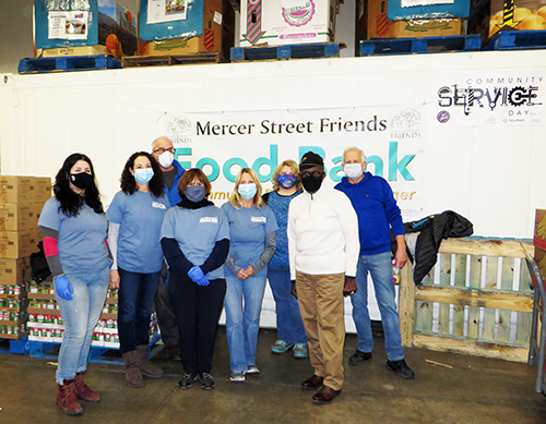 Staff pose with MSF's Director and another volunteer after packing family food bags. Photo by DRBC.