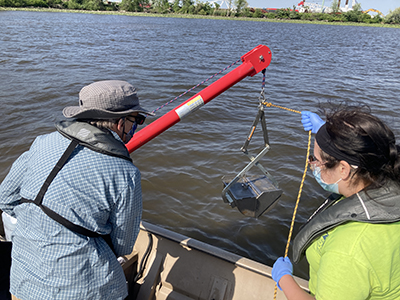 DRBC staff pull a sediment sample from the Delaware River to monitor for PFAS. Photo by DRBC.