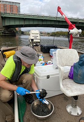 DRBC staff collects a sediment sample from the Delaware River to monitor for PFAS. Photo by DRBC.