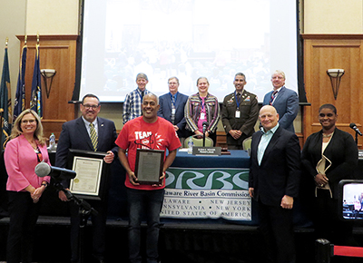 DRBC Commissioners and special guests honor the City of Camden. Top, L to R: Delaware Alternate Commissioner Stephen N. Williams; New Jersey Alternate Commissioner Jeffrey Hoffman; Pennsylvania Alternate Commissioner Susan Weaver; Federal Government Alternate Commissioner LTC Ramon Brigantti; and New York Alternate Commissioner Ken Kosinski. Bottom L to R: NJDEP's Elizabeth Dragon; DRBC's Steve Tambini; Camden Mayor Vic Carstarphen; Camden County Commissioner Jeff Nash; and USEPA Region 2's Olivia Glenn. Photo by the DRBC.