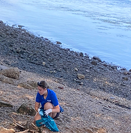 Water Quality Intern Bailey Adams cleans up trash along the Delaware River. Photo by the DRBC.