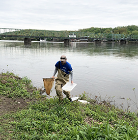 DRBC Aquatic Biologist Jake Bransky brings the collected sample from the river to our demonstration table. Photo by DRBC.